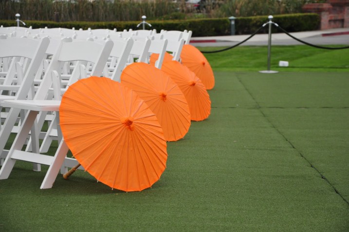 mango colored parasols lined the outer aisles of the ceremony